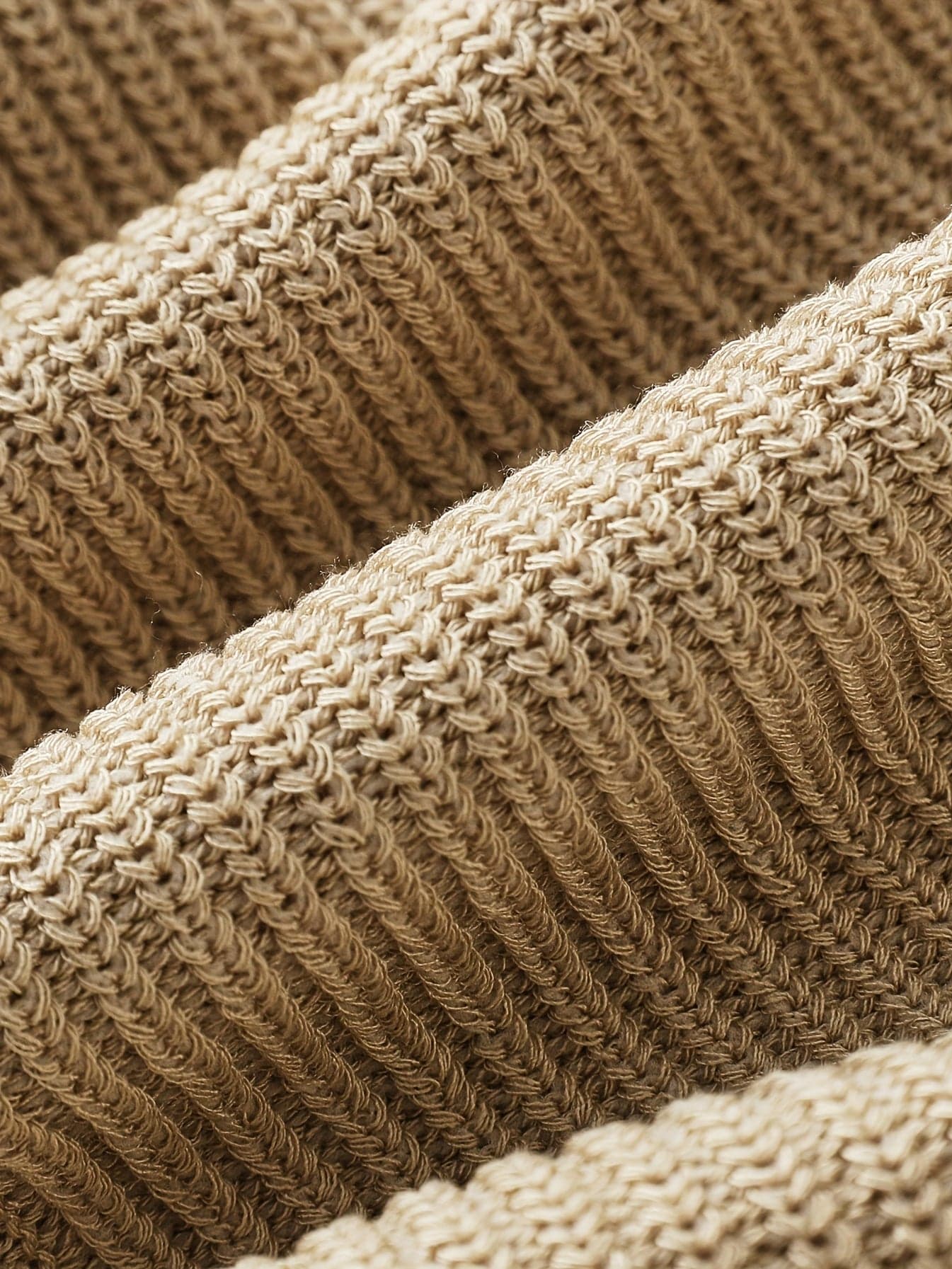 Kvinde iført en beige åben striktrøje med afslappet pasform og luftig åben strik._3