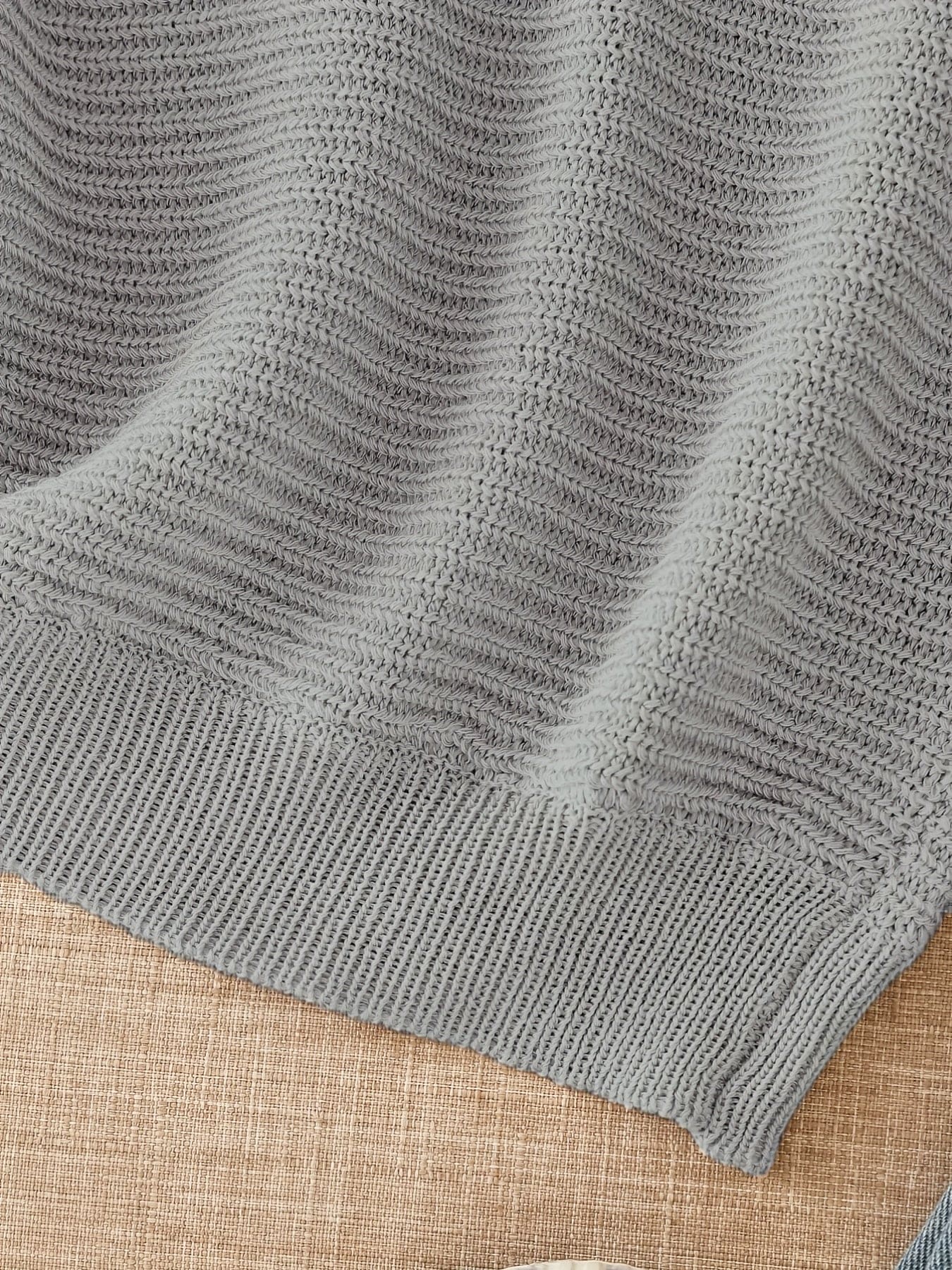 Kvinde iført en beige åben striktrøje med afslappet pasform og luftig åben strik._43