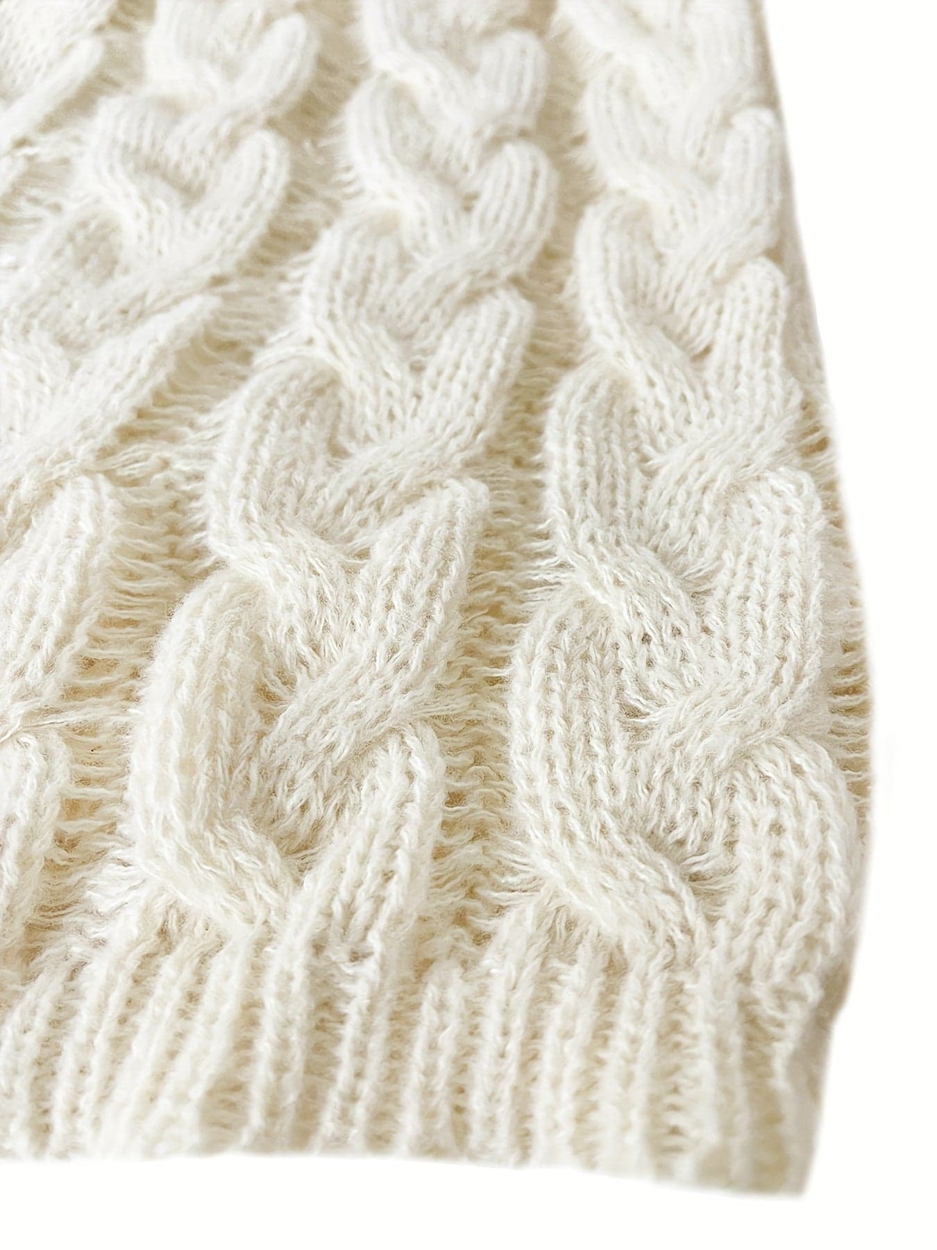 Kvinde iført en afslappet cable-knit sweater med v-hals og langt perlearmbånd_2