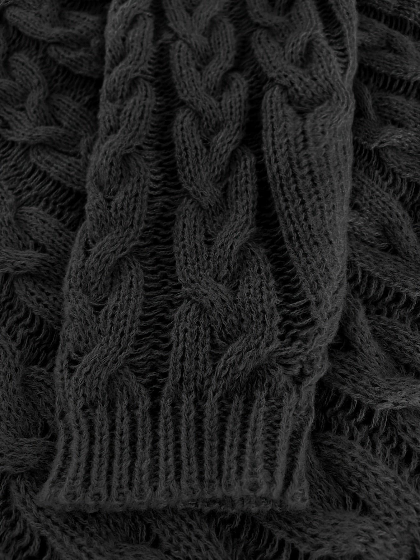 Kvinde iført en afslappet cable-knit sweater med v-hals og langt perlearmbånd_6
