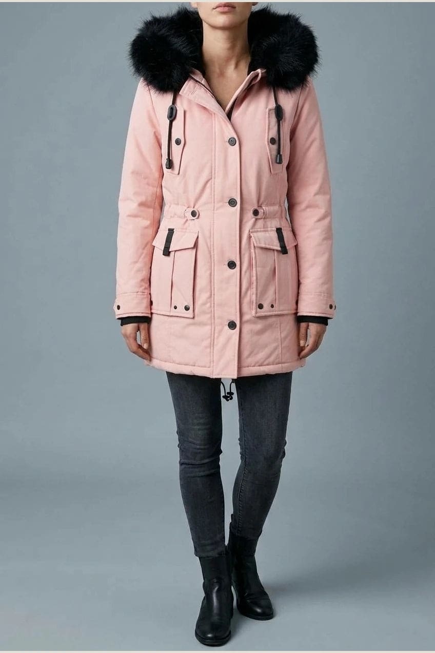 Kvinde i lang vatteret parka med pelskant på hætten, knaprække, taljebånd og fire klaplommer, styles med jeans og støvler._12