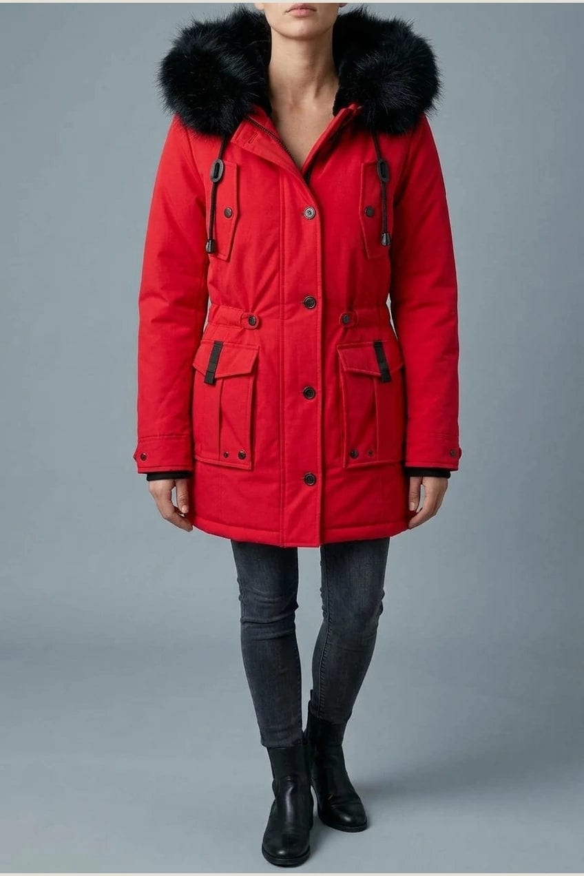 Kvinde i lang vatteret parka med pelskant på hætten, knaprække, taljebånd og fire klaplommer, styles med jeans og støvler._18