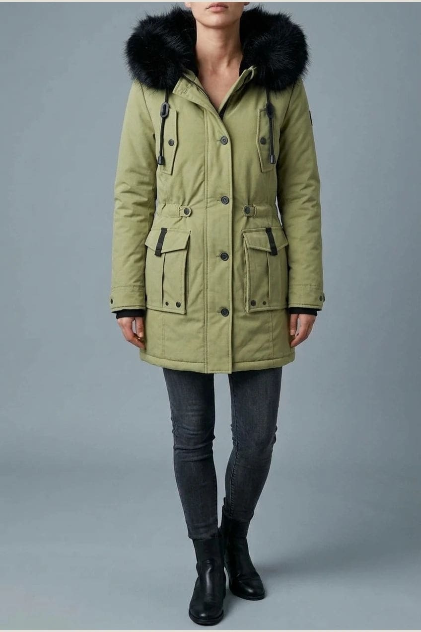 Kvinde i lang vatteret parka med pelskant på hætten, knaprække, taljebånd og fire klaplommer, styles med jeans og støvler._6