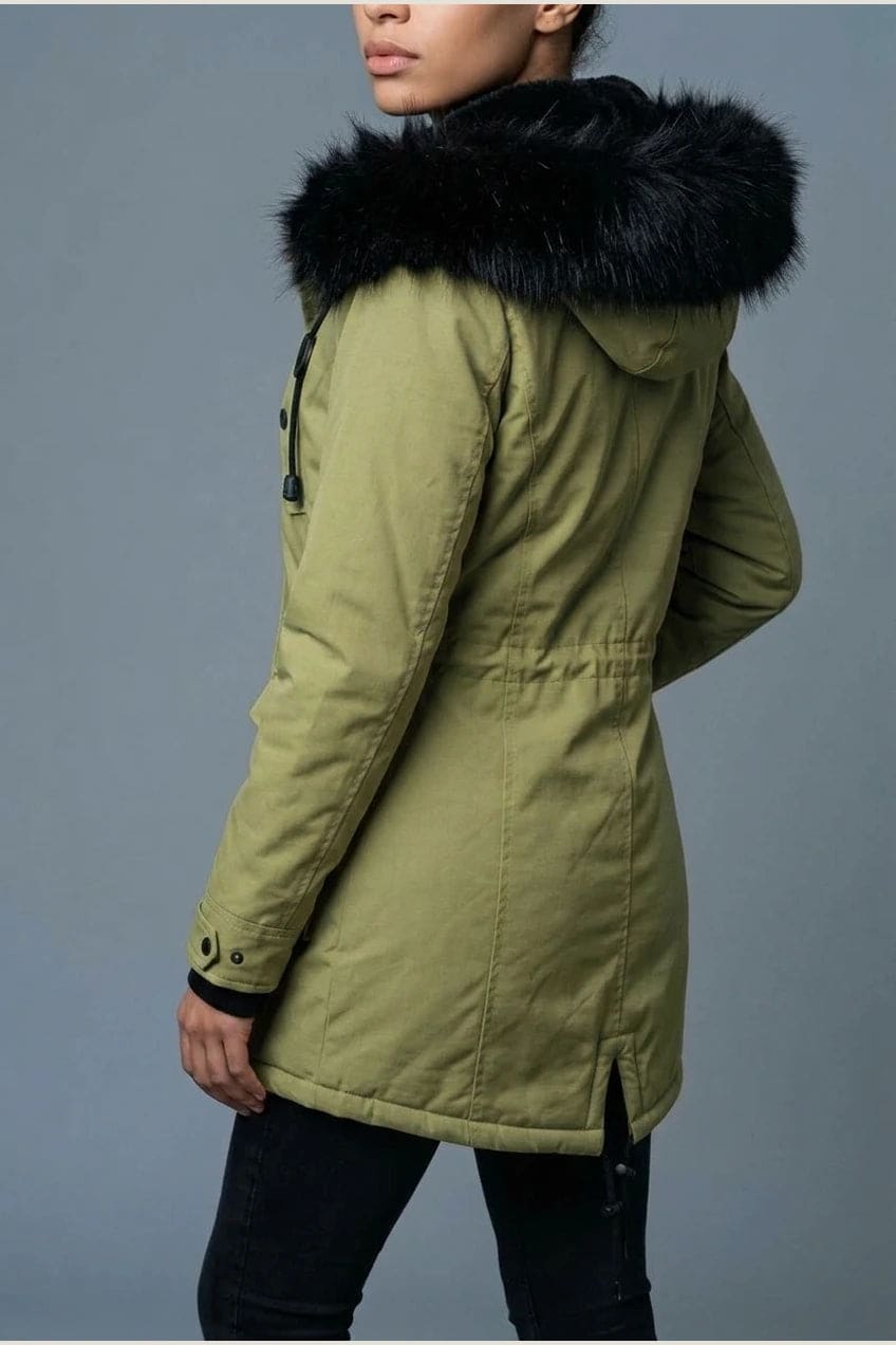 Kvinde i lang vatteret parka med pelskant på hætten, knaprække, taljebånd og fire klaplommer, styles med jeans og støvler._9