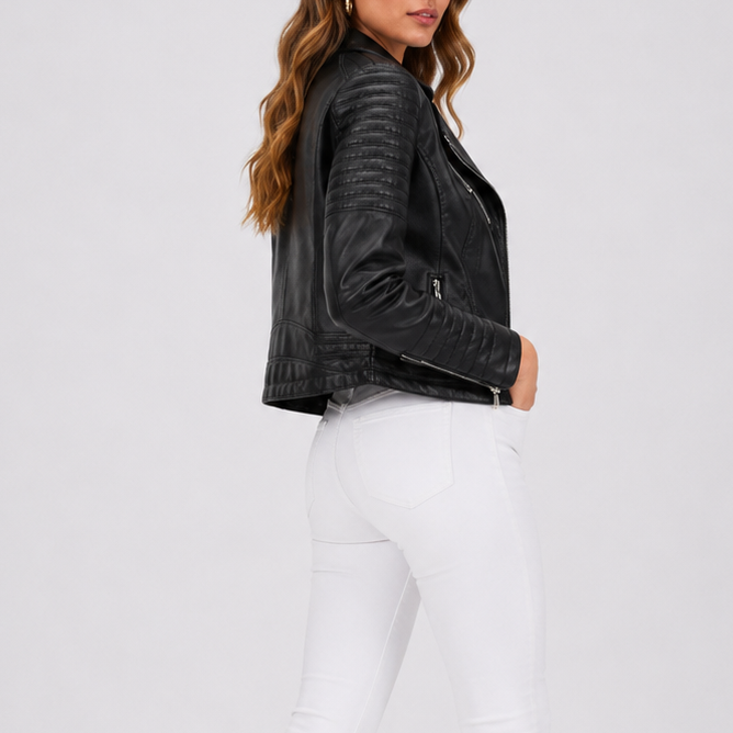 Kvinde iført sort bikerjakke med asymmetrisk lynlås, quiltede ærmer og revers, stylet med hvide jeans._2