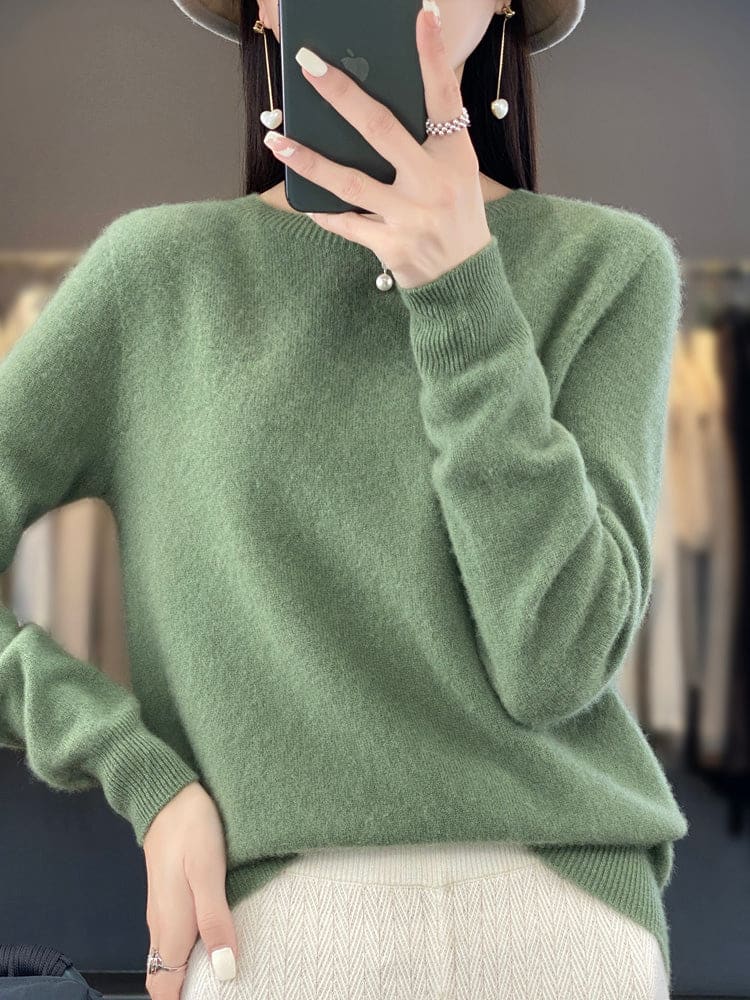 Kvinde fotograferer sig selv i et spejl iført en sage grøn, blød strikket sweater med afslappet pasform og rund hals._0