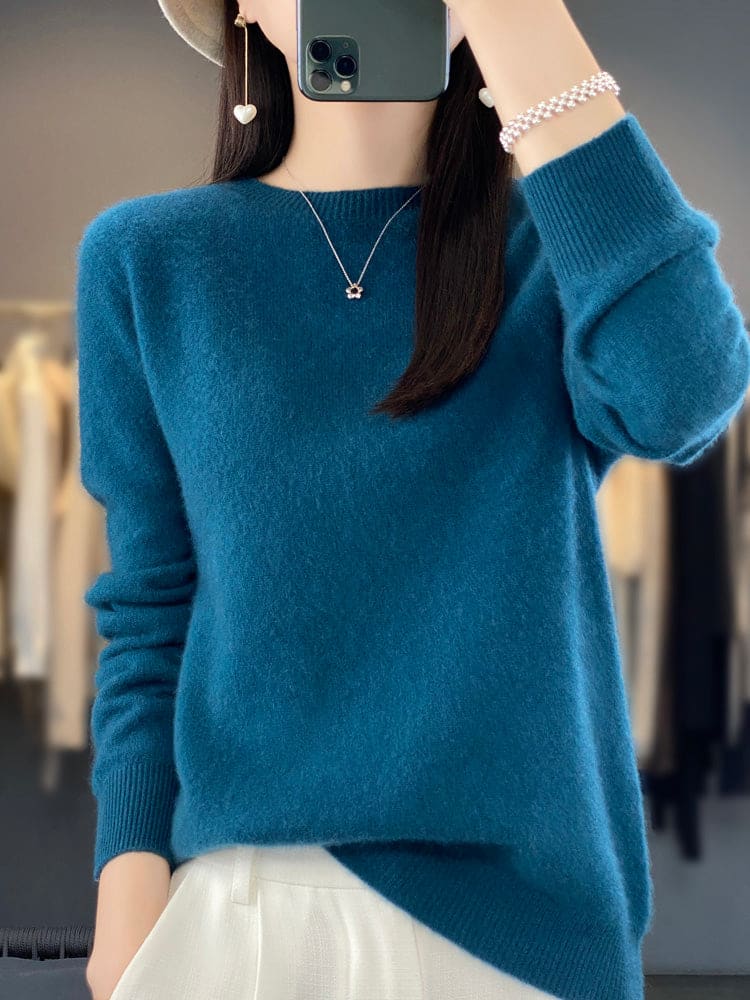 Kvinde fotograferer sig selv i et spejl iført en sage grøn, blød strikket sweater med afslappet pasform og rund hals._1