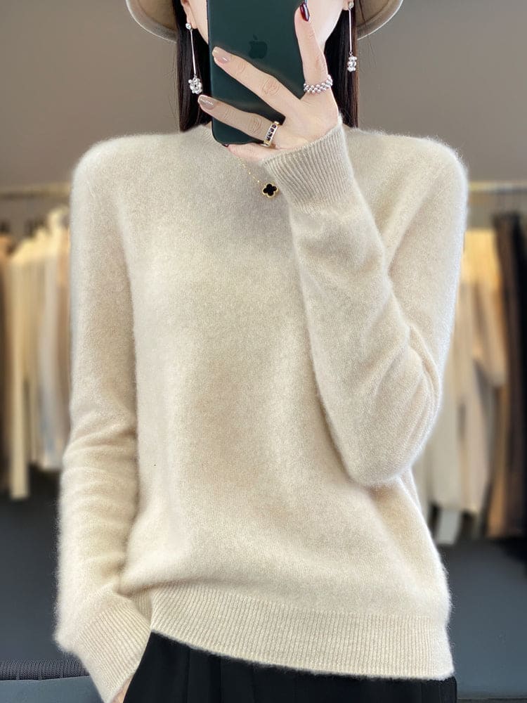 Kvinde fotograferer sig selv i et spejl iført en sage grøn, blød strikket sweater med afslappet pasform og rund hals._10