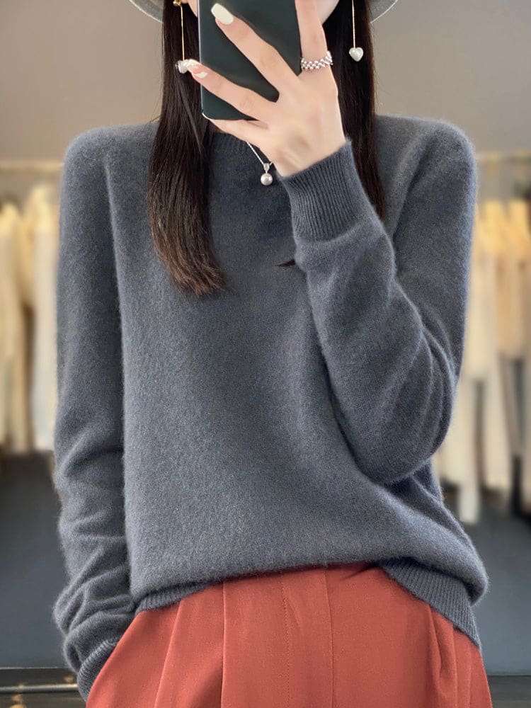 Kvinde fotograferer sig selv i et spejl iført en sage grøn, blød strikket sweater med afslappet pasform og rund hals._11