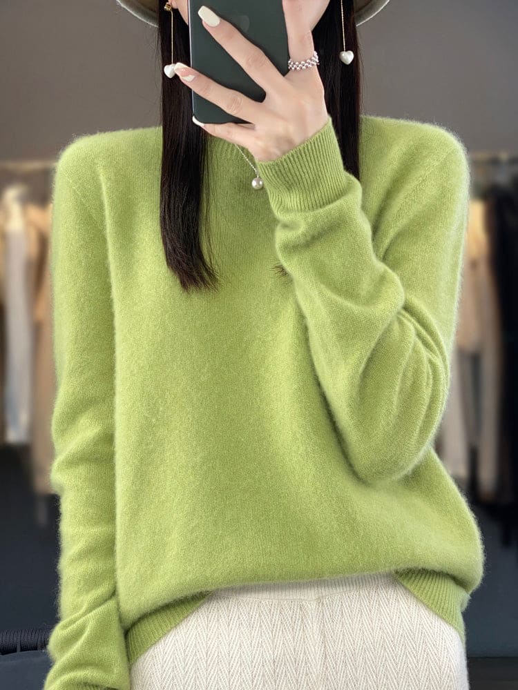 Kvinde fotograferer sig selv i et spejl iført en sage grøn, blød strikket sweater med afslappet pasform og rund hals._12