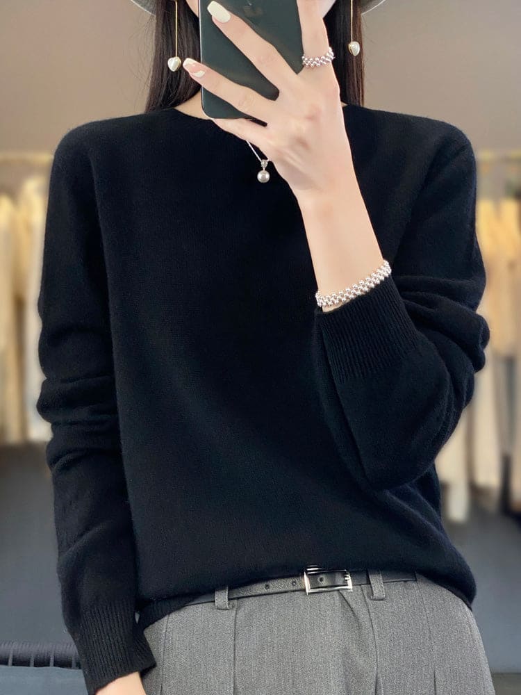 Kvinde fotograferer sig selv i et spejl iført en sage grøn, blød strikket sweater med afslappet pasform og rund hals._13