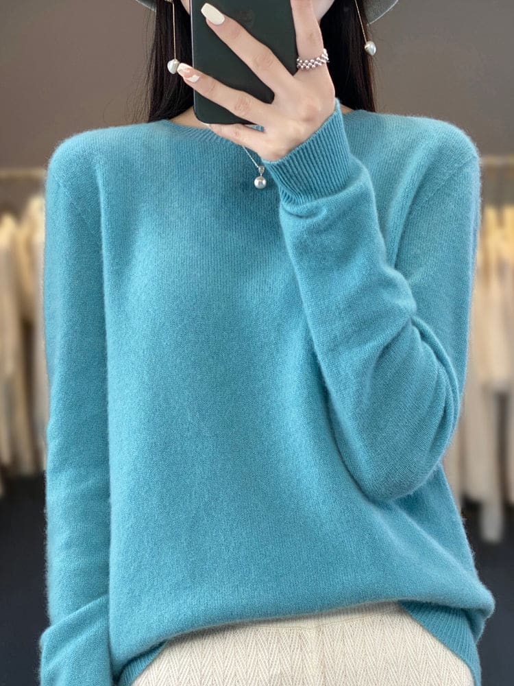 Kvinde fotograferer sig selv i et spejl iført en sage grøn, blød strikket sweater med afslappet pasform og rund hals._4