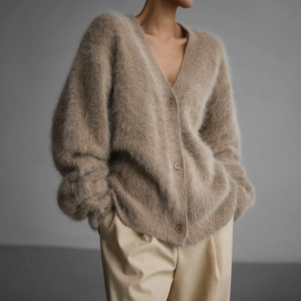 Kvinde iført en lys beige oversize cardigan med knaplukning og v-hals, parret med lyse bukser._0