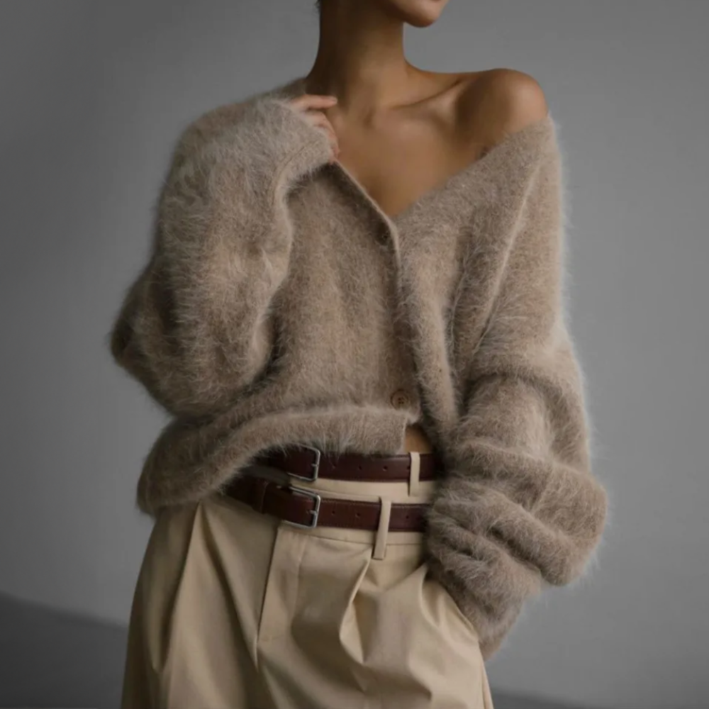 Kvinde iført en lys beige oversize cardigan med knaplukning og v-hals, parret med lyse bukser._1