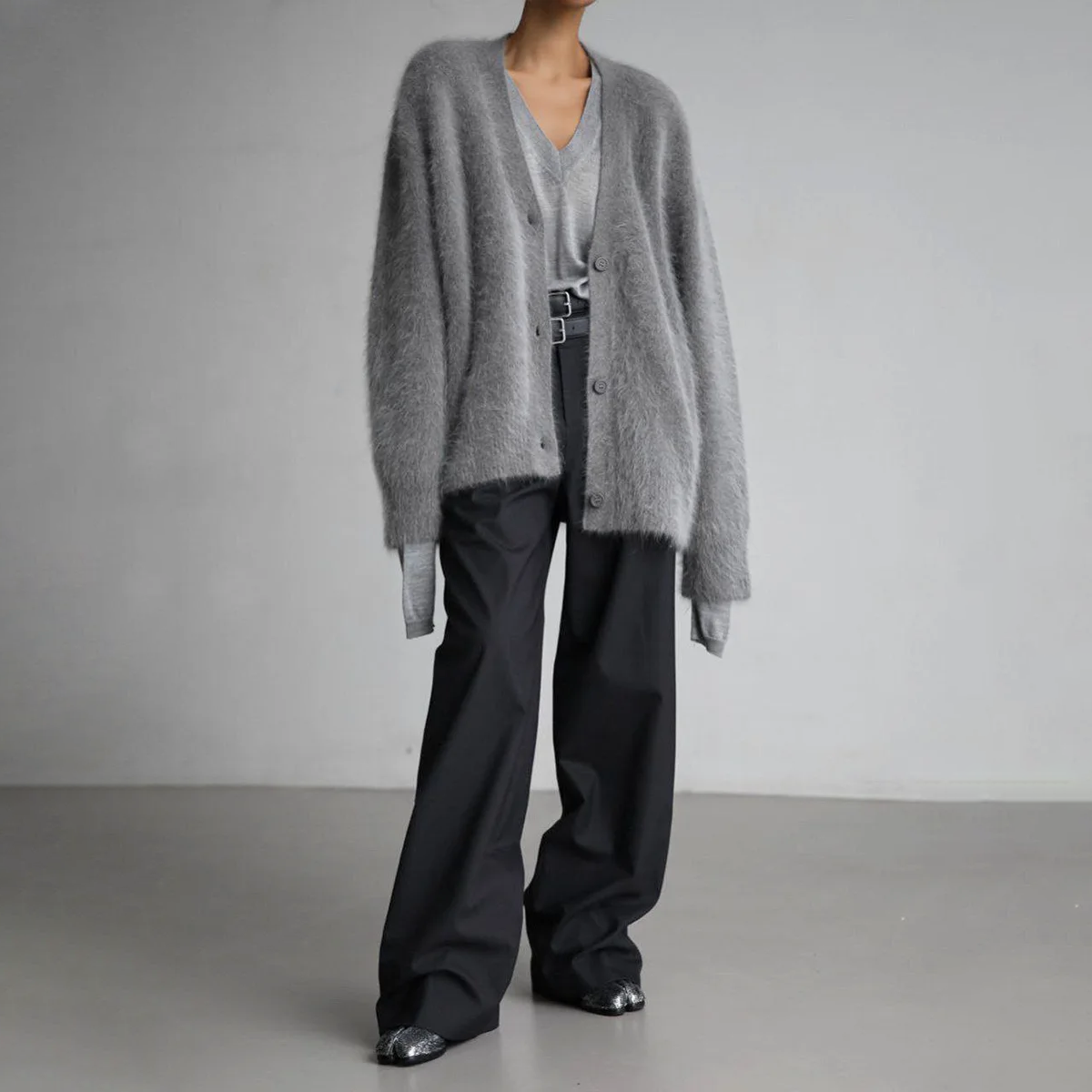 Kvinde iført en lys beige oversize cardigan med knaplukning og v-hals, parret med lyse bukser._4