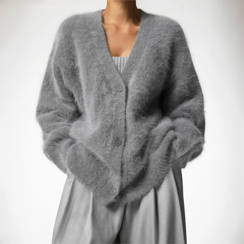 Kvinde iført en lys beige oversize cardigan med knaplukning og v-hals, parret med lyse bukser._5