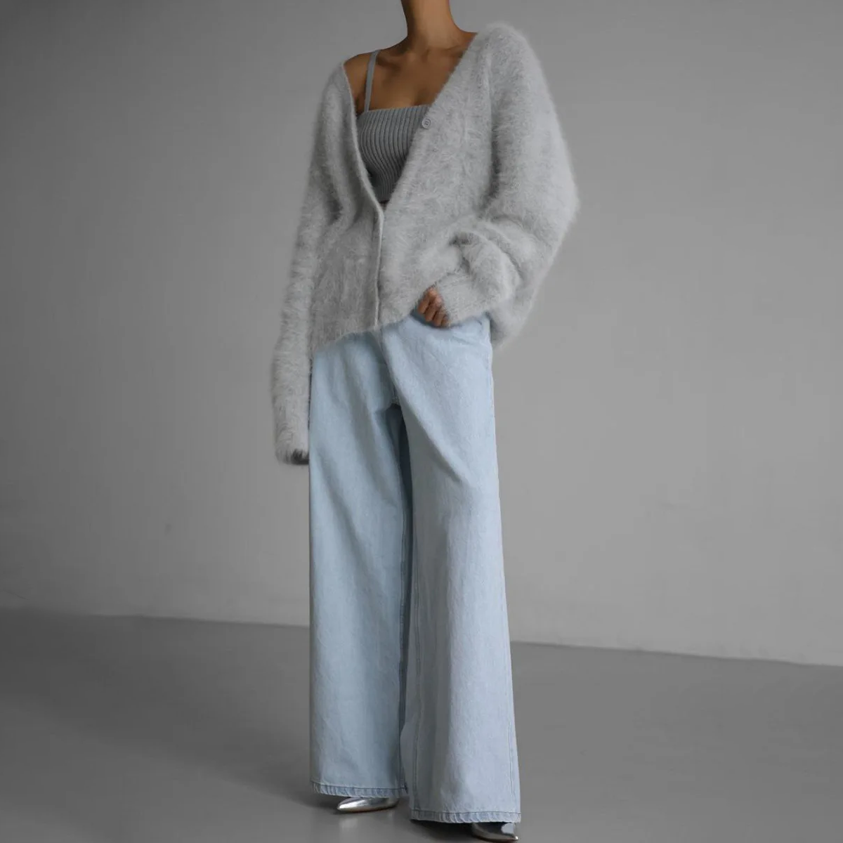 Kvinde iført en lys beige oversize cardigan med knaplukning og v-hals, parret med lyse bukser._8