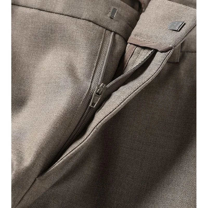 Kvinde iført sorte loafers, grå bukser med høj talje og sort cardigan i neutral kulisse._10