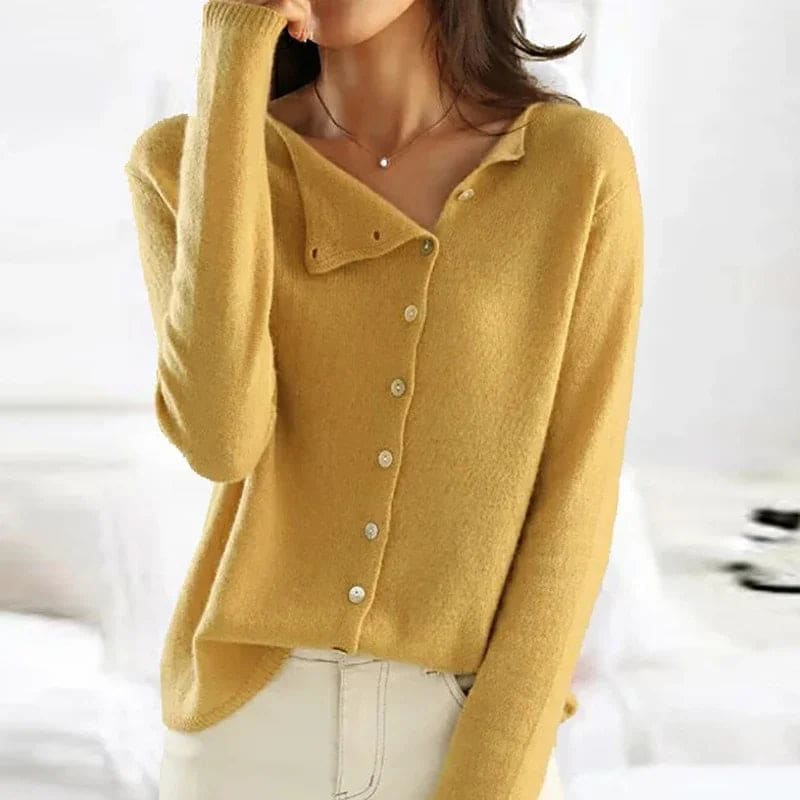 Model iført gul cardigan med asymmetrisk knaplukning og klassisk krave, stylet med hvide bukser_0