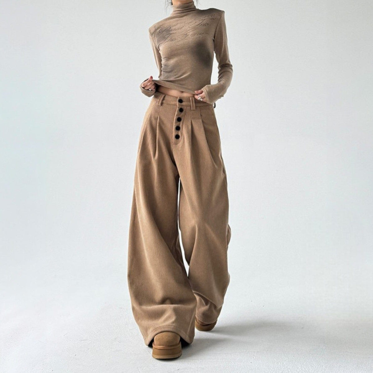 Model iført bukser med høj talje, knapper foran og brede ben._2