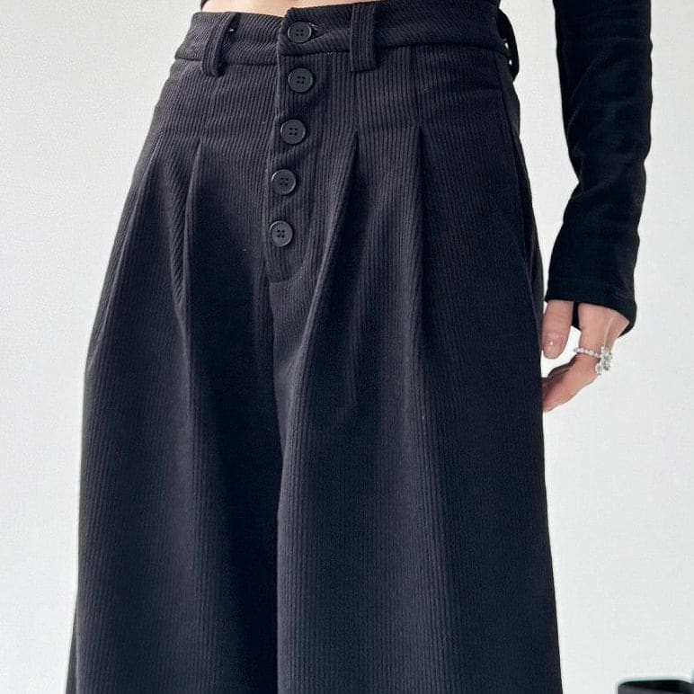 Model iført bukser med høj talje, knapper foran og brede ben._8