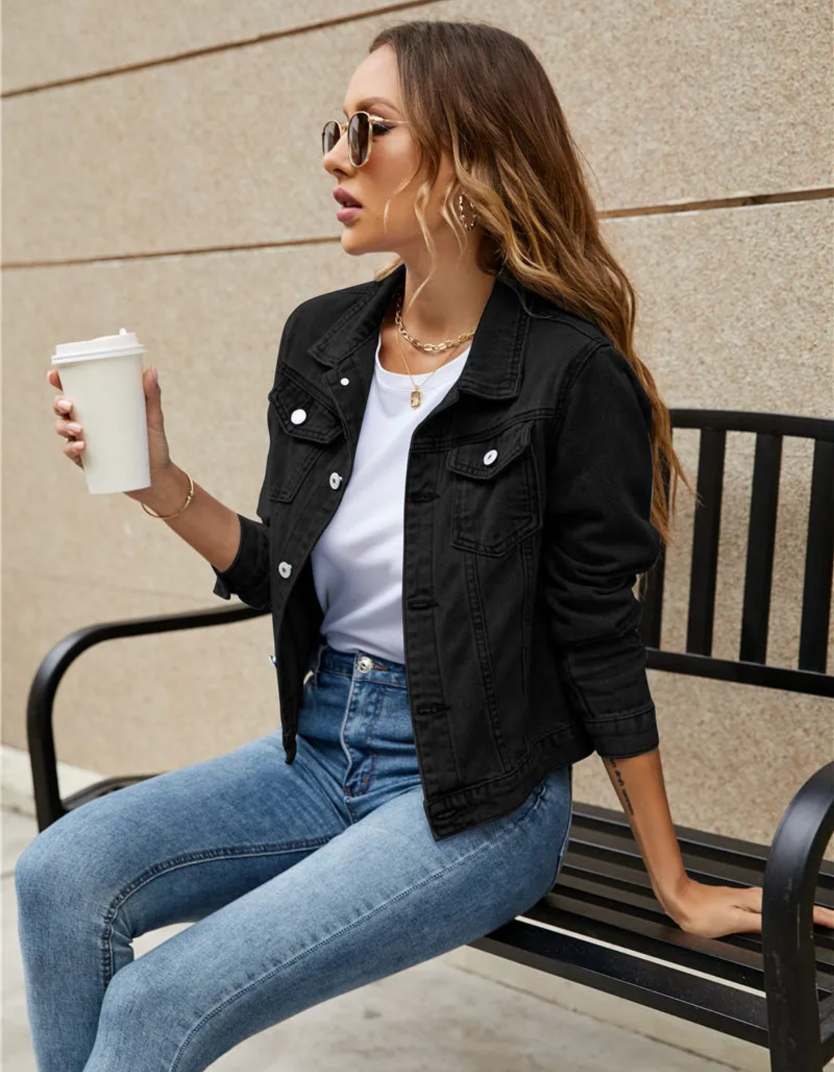 Kort denimjakke med skjortekrave, knaplukning foran og to brystlommer med klap, båret åben over en hvid t-shirt og jeans._1