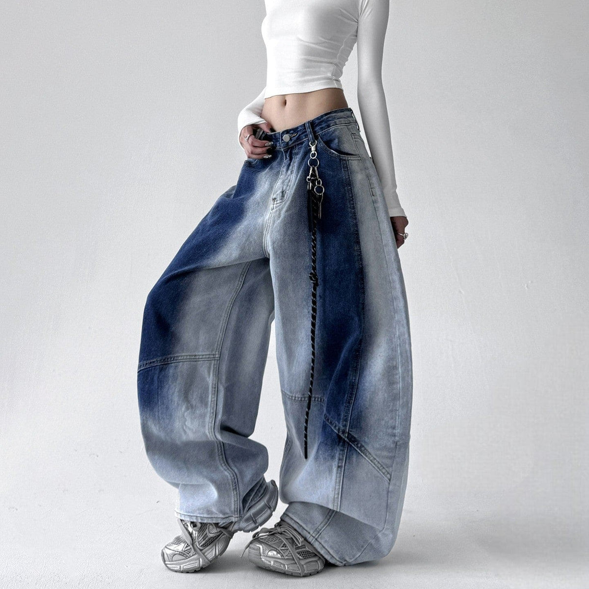 Model iført jeans med ekstra vide ben, buede sømme og en kædedetalje ved hoften._0