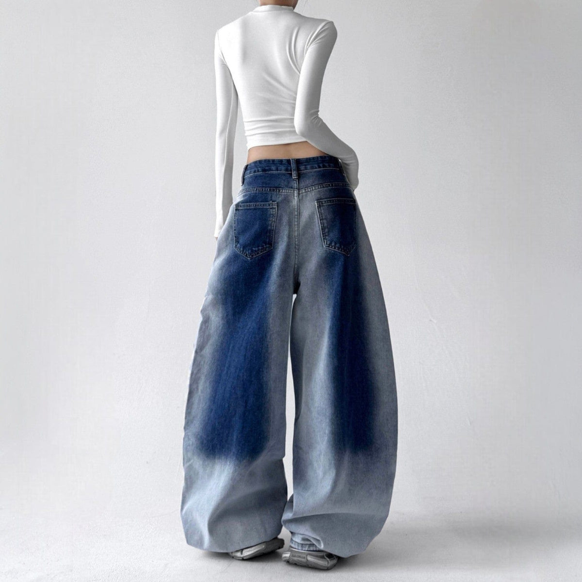 Model iført jeans med ekstra vide ben, buede sømme og en kædedetalje ved hoften._1