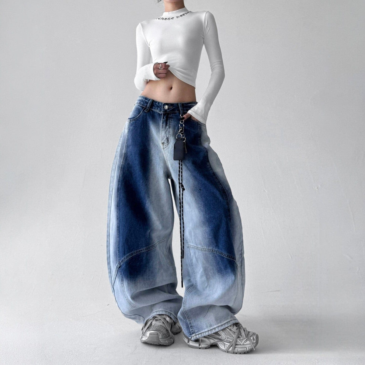 Model iført jeans med ekstra vide ben, buede sømme og en kædedetalje ved hoften._2