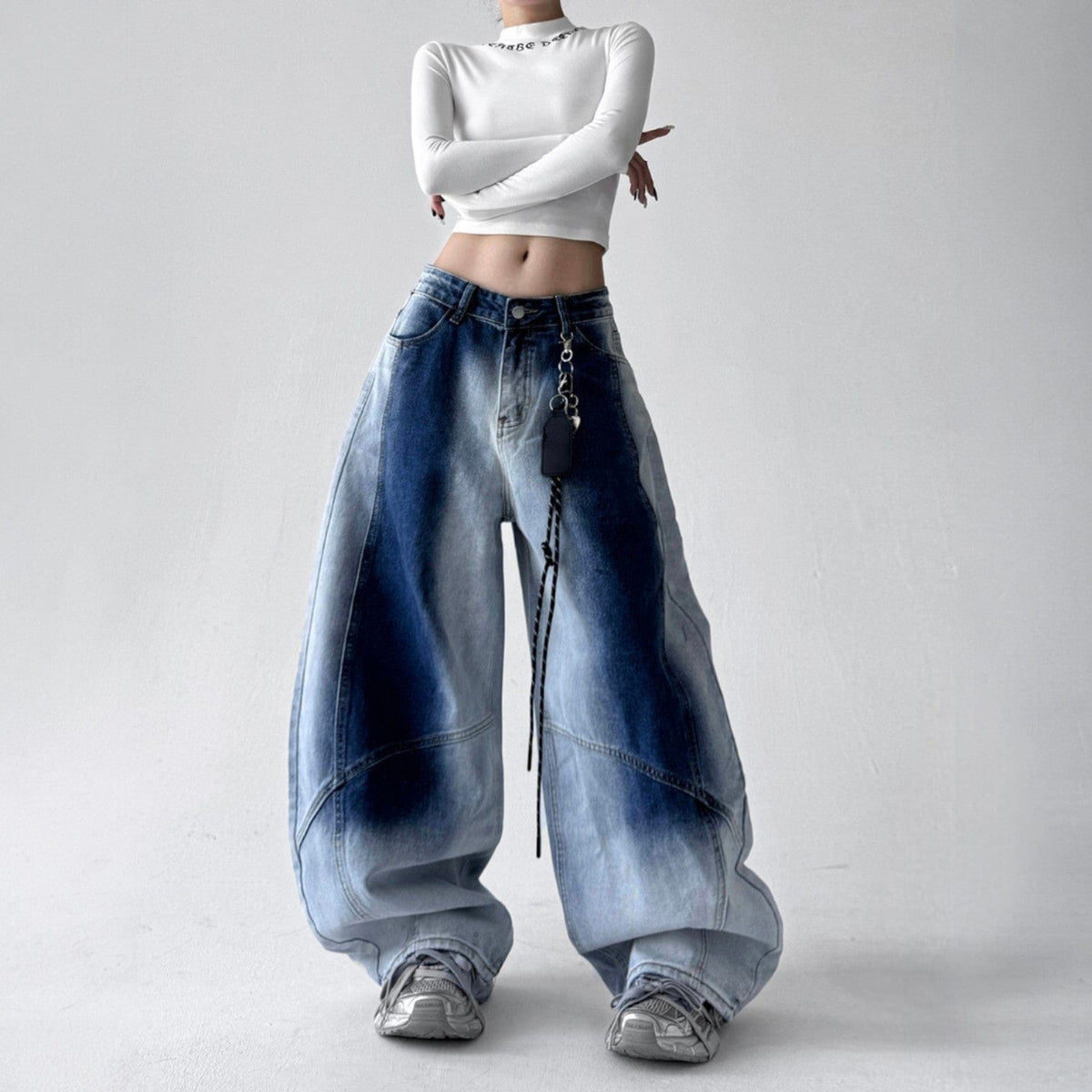 Model iført jeans med ekstra vide ben, buede sømme og en kædedetalje ved hoften._3