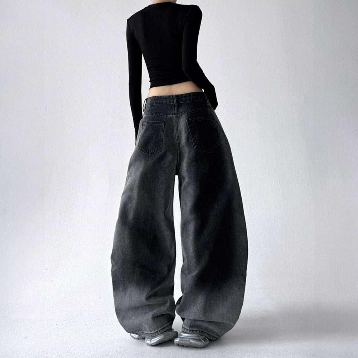 Model iført jeans med ekstra vide ben, buede sømme og en kædedetalje ved hoften._5