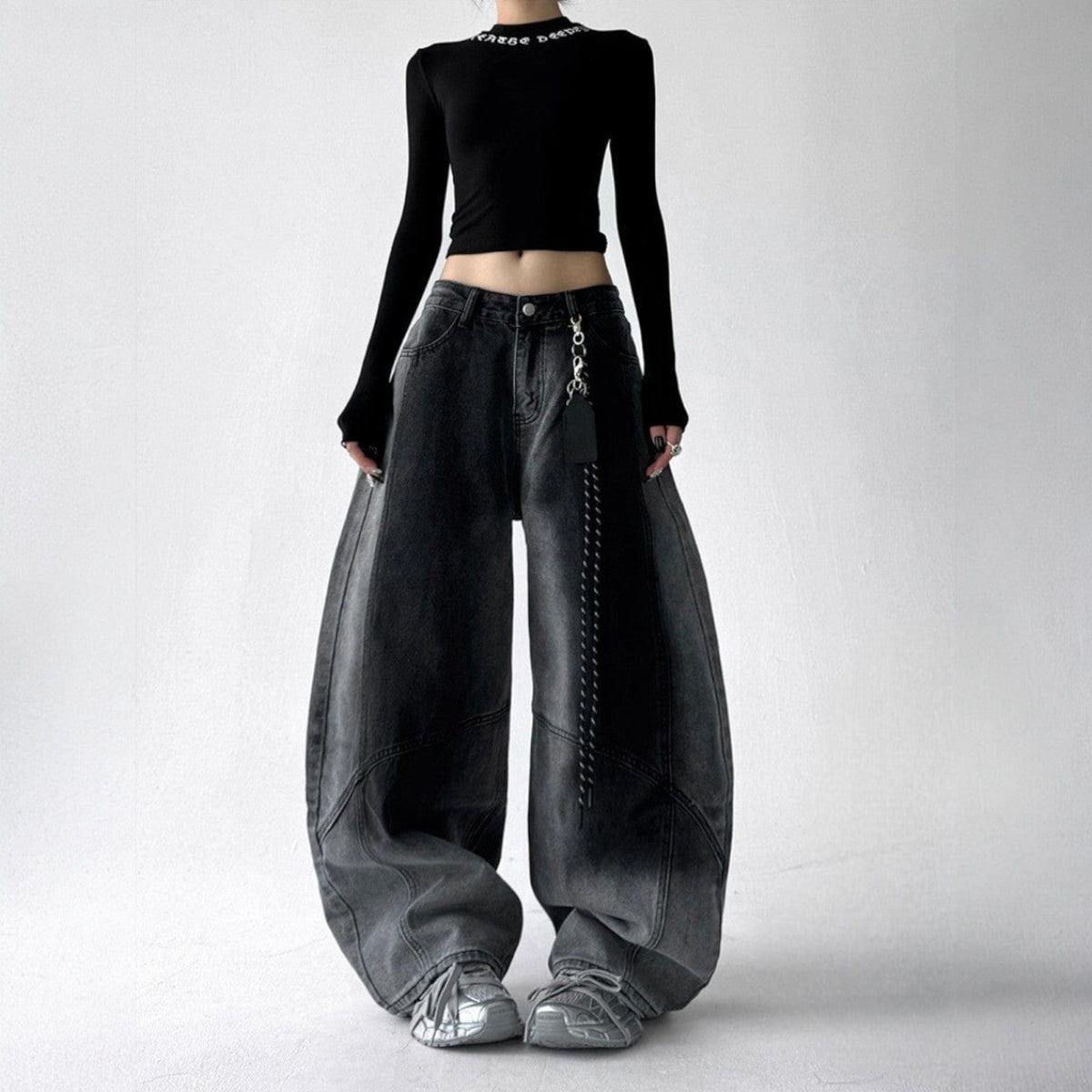 Model iført jeans med ekstra vide ben, buede sømme og en kædedetalje ved hoften._7