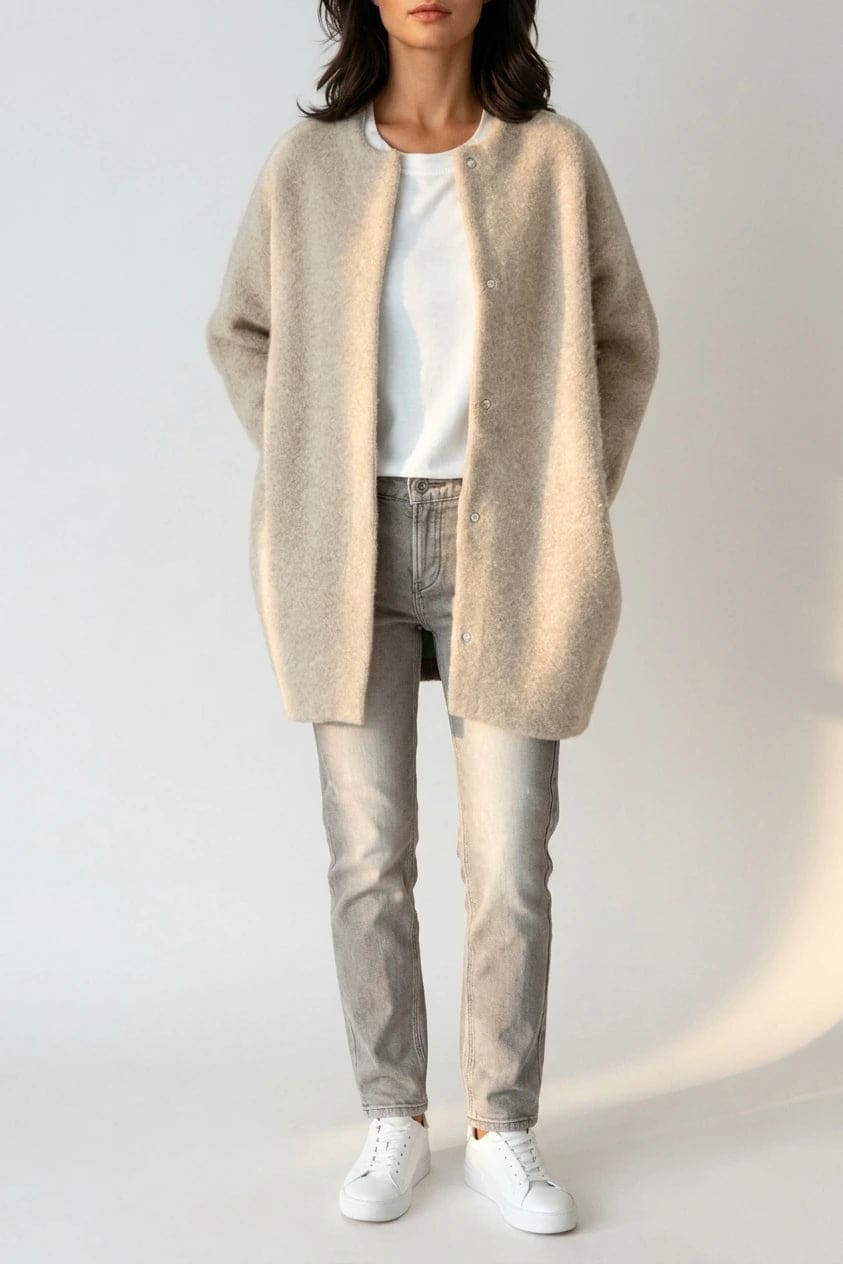Kvinde i lang oversize cardigan med rund hals og knapper, hvid t-shirt, jeans og sneakers._0