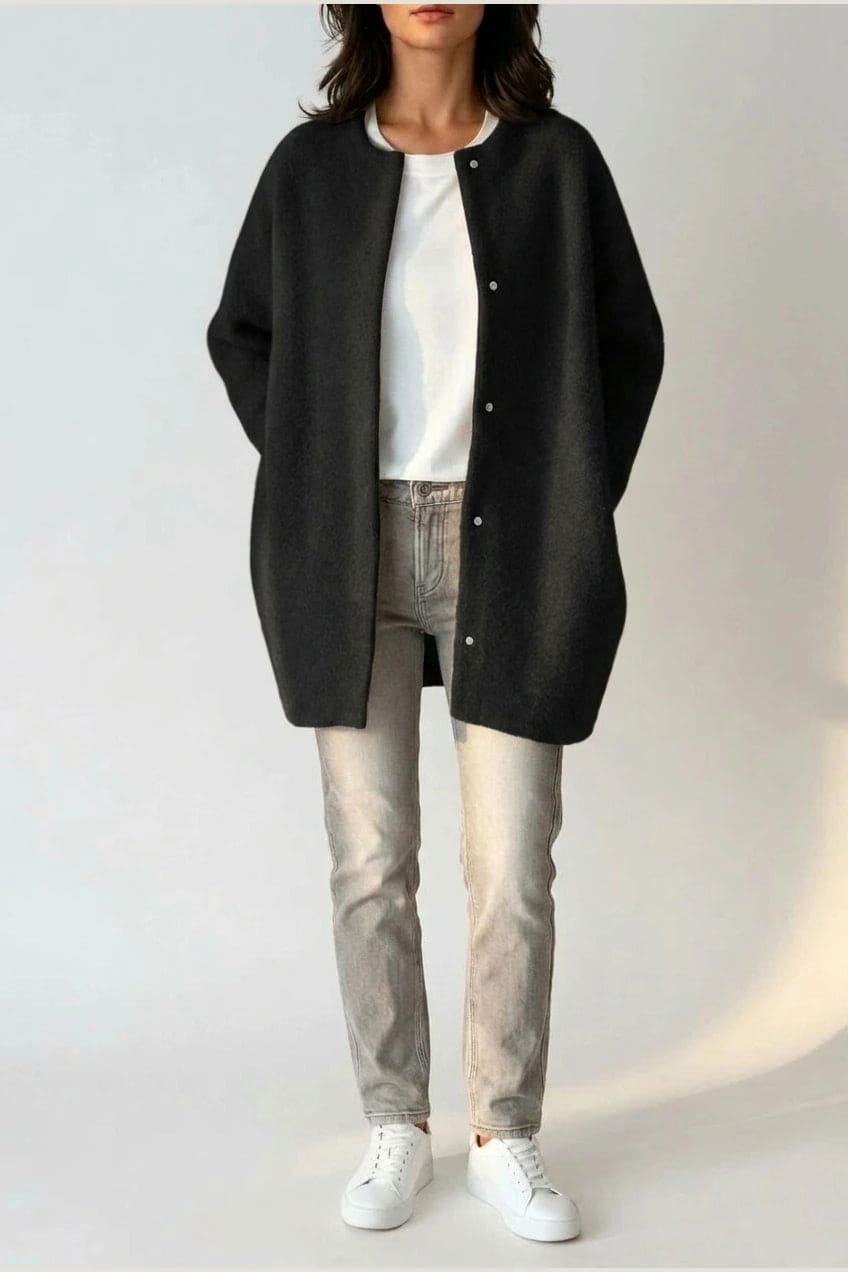 Kvinde i lang oversize cardigan med rund hals og knapper, hvid t-shirt, jeans og sneakers._1