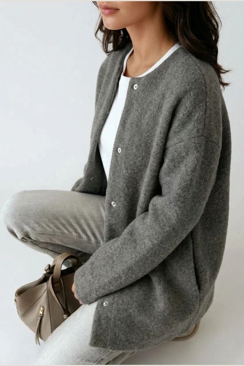 Kvinde i lang oversize cardigan med rund hals og knapper, hvid t-shirt, jeans og sneakers._10