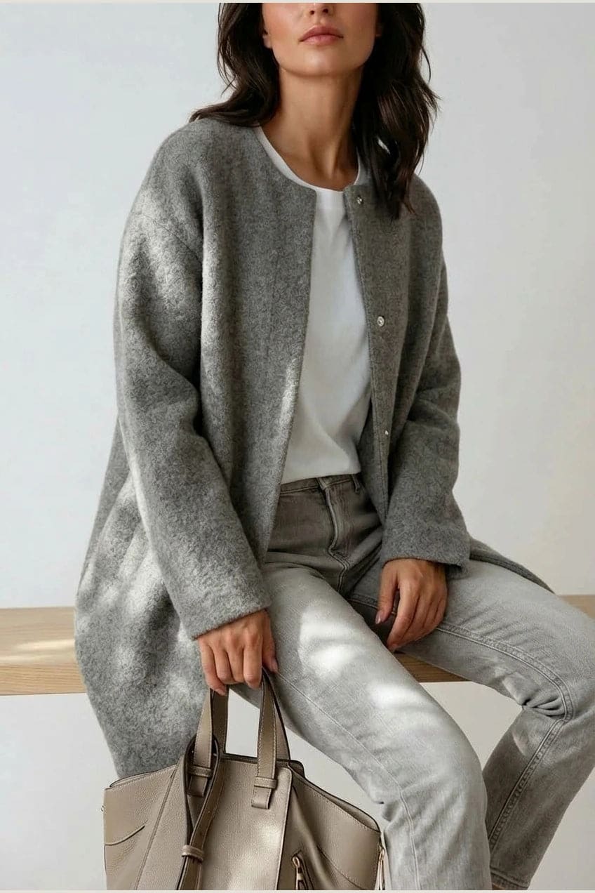 Kvinde i lang oversize cardigan med rund hals og knapper, hvid t-shirt, jeans og sneakers._11