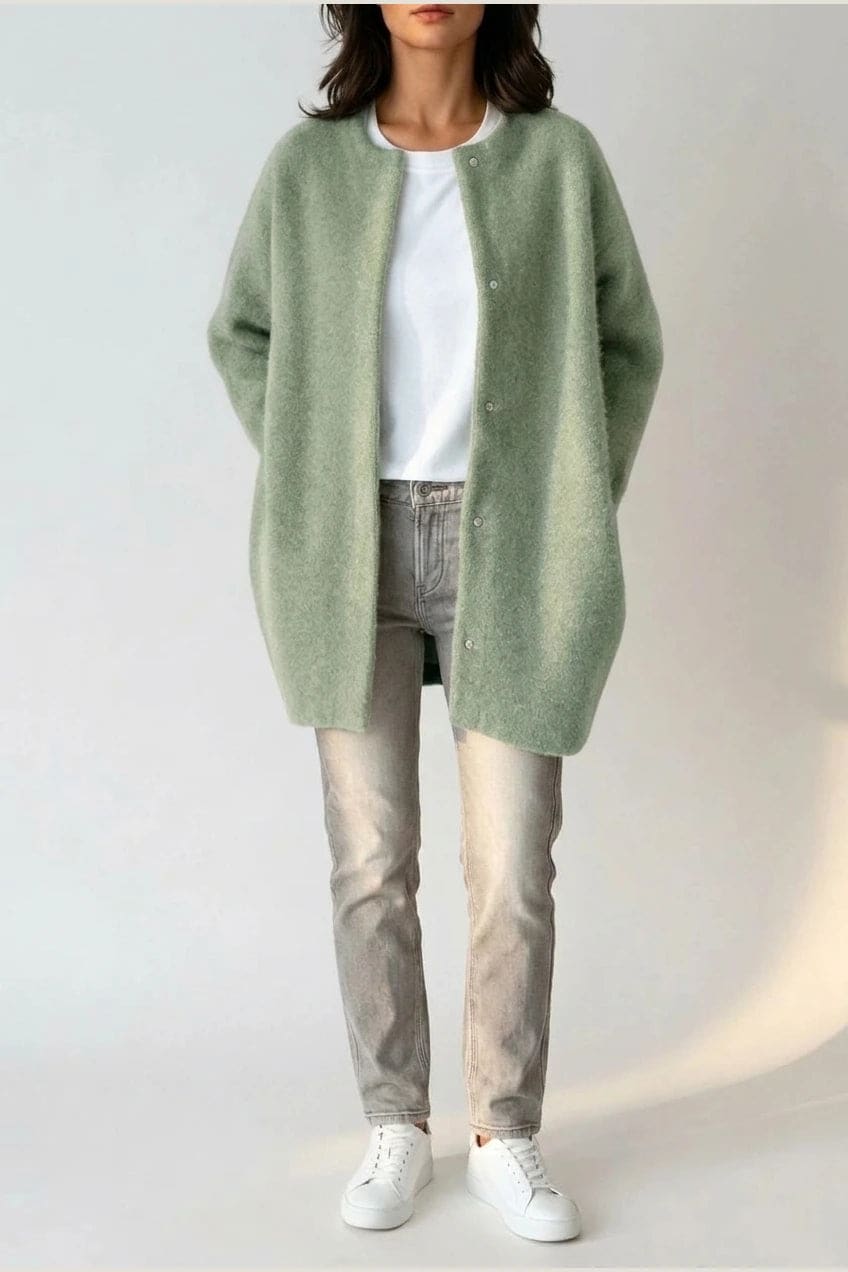 Kvinde i lang oversize cardigan med rund hals og knapper, hvid t-shirt, jeans og sneakers._13