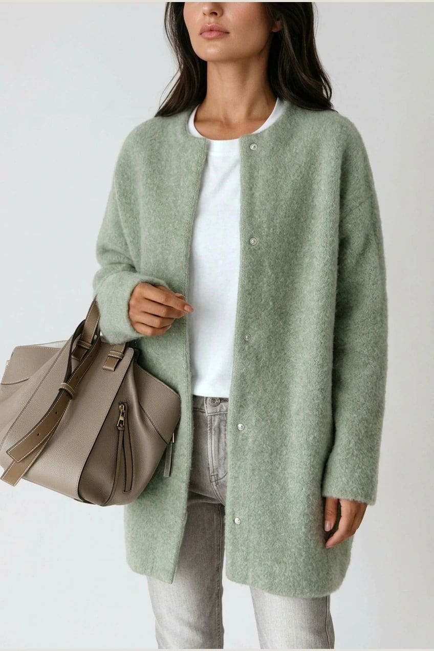 Kvinde i lang oversize cardigan med rund hals og knapper, hvid t-shirt, jeans og sneakers._14