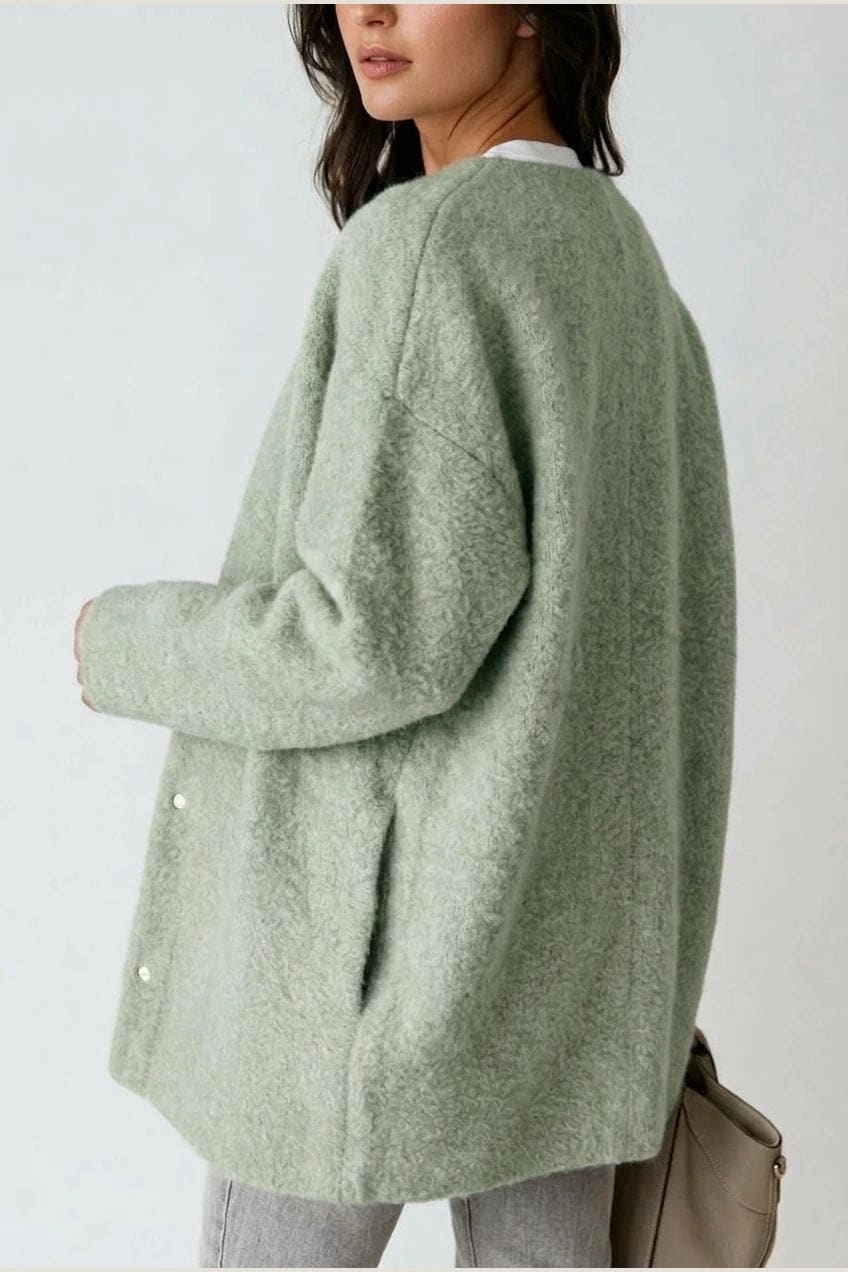Kvinde i lang oversize cardigan med rund hals og knapper, hvid t-shirt, jeans og sneakers._15