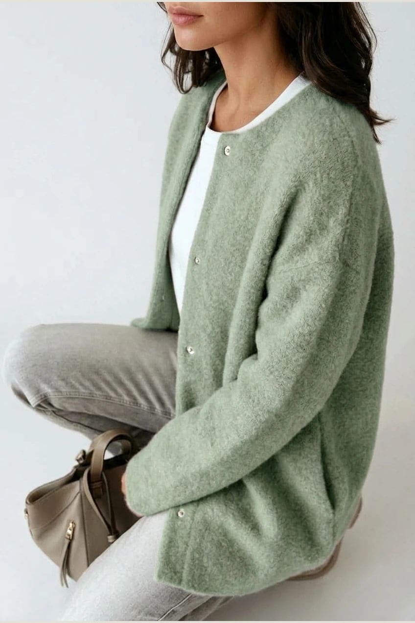 Kvinde i lang oversize cardigan med rund hals og knapper, hvid t-shirt, jeans og sneakers._16