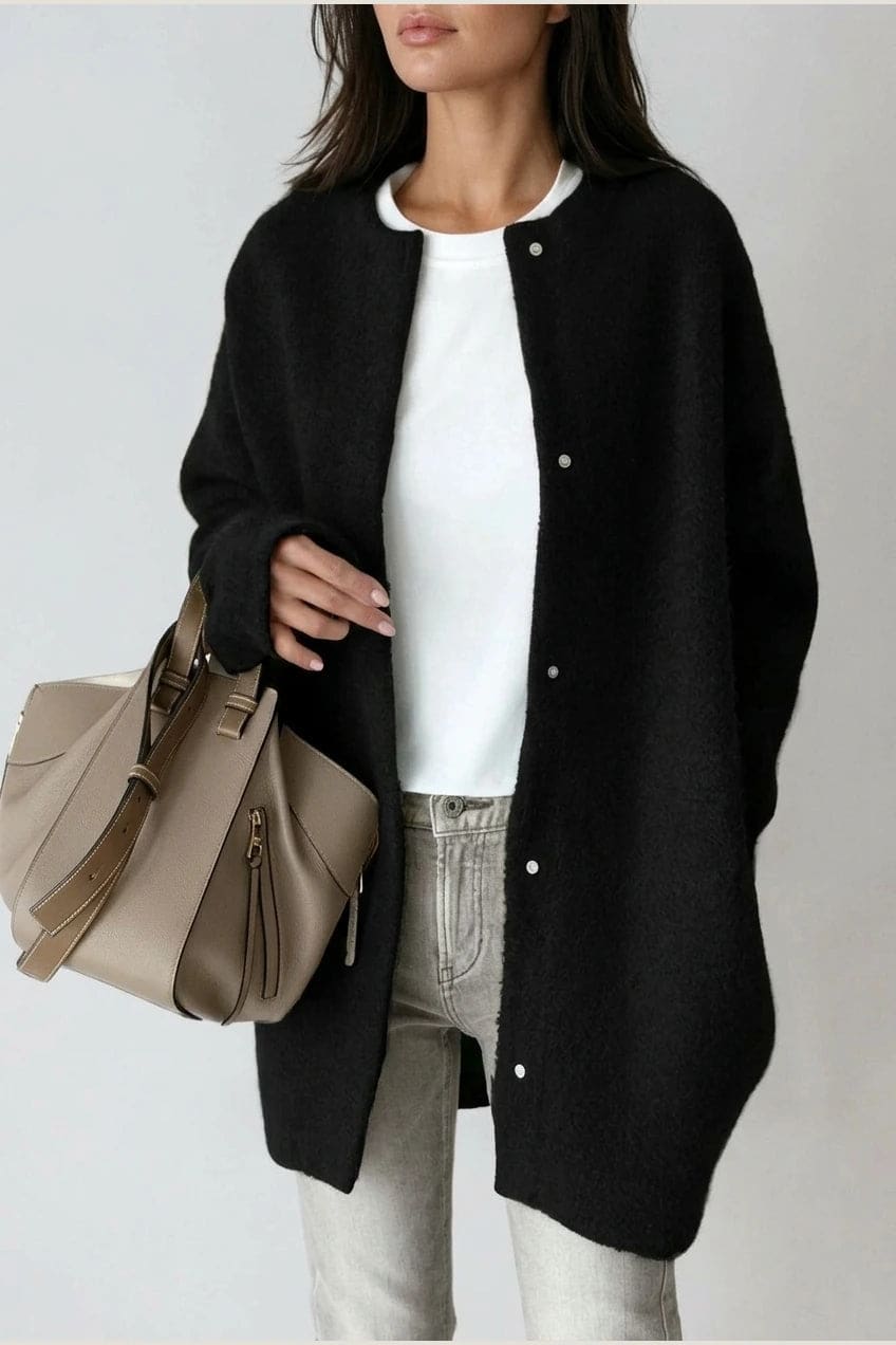 Kvinde i lang oversize cardigan med rund hals og knapper, hvid t-shirt, jeans og sneakers._2