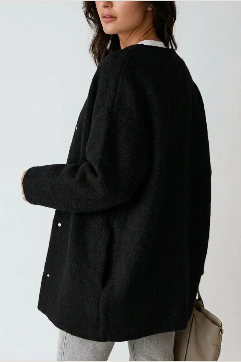 Kvinde i lang oversize cardigan med rund hals og knapper, hvid t-shirt, jeans og sneakers._3