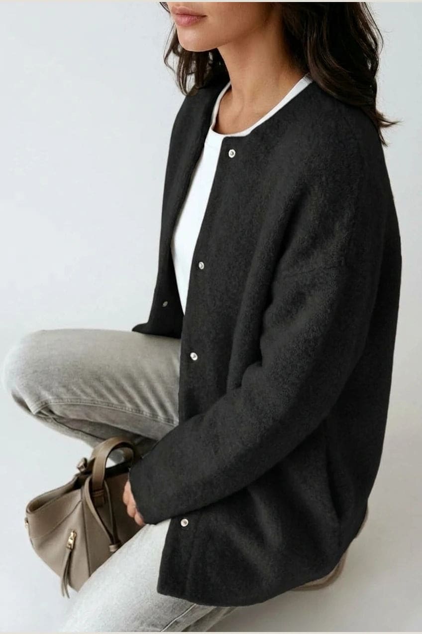 Kvinde i lang oversize cardigan med rund hals og knapper, hvid t-shirt, jeans og sneakers._4