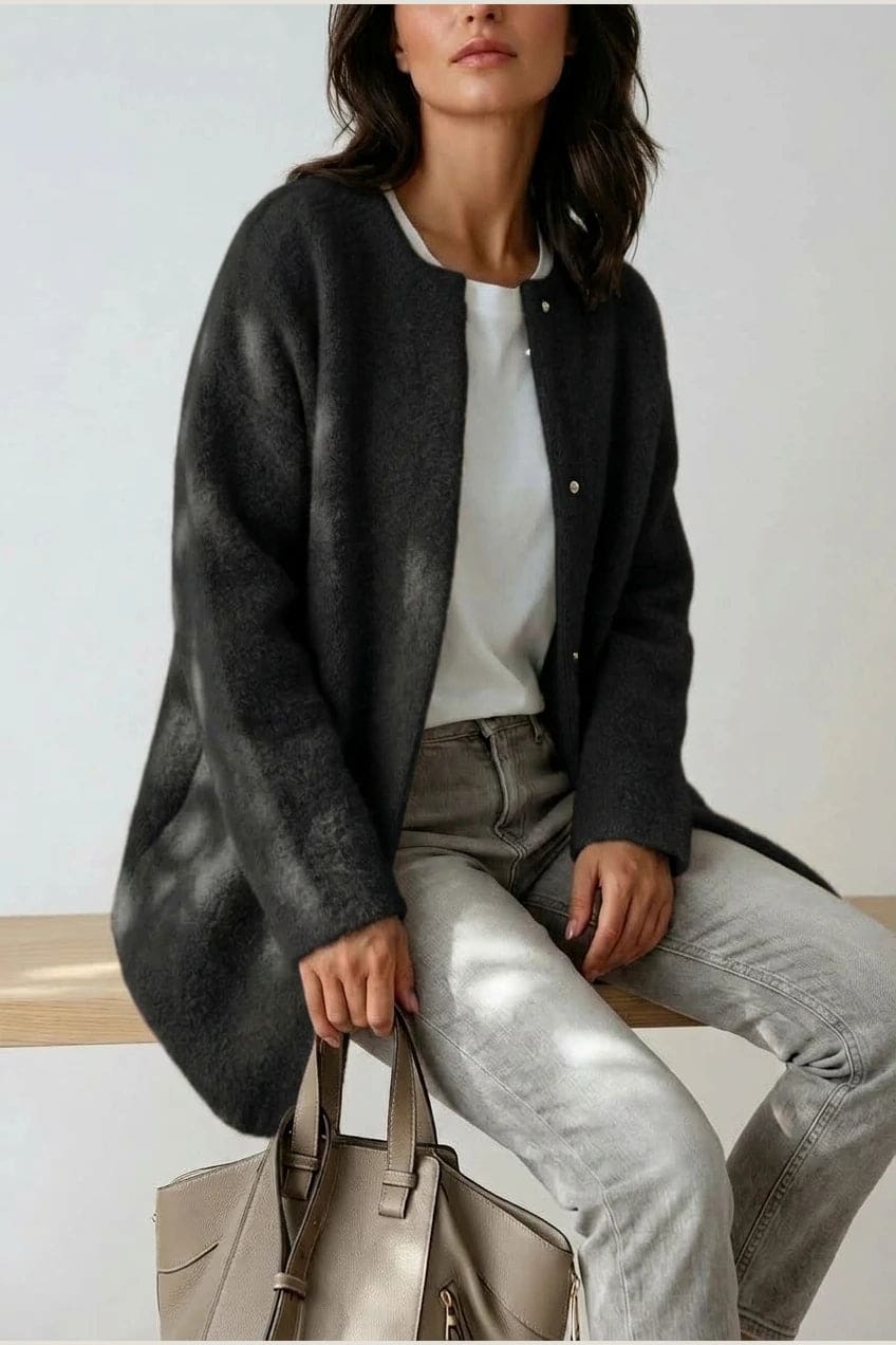 Kvinde i lang oversize cardigan med rund hals og knapper, hvid t-shirt, jeans og sneakers._5