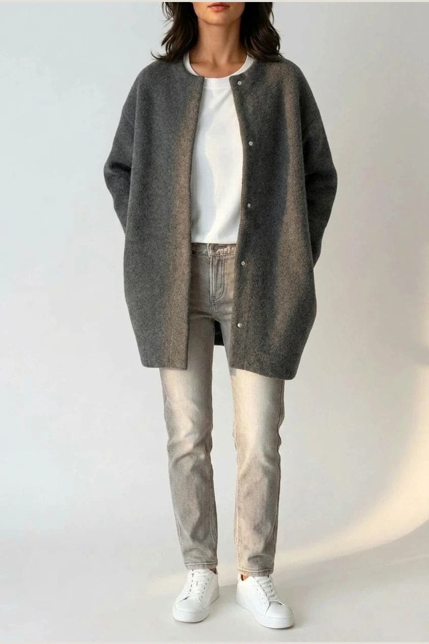 Kvinde i lang oversize cardigan med rund hals og knapper, hvid t-shirt, jeans og sneakers._7