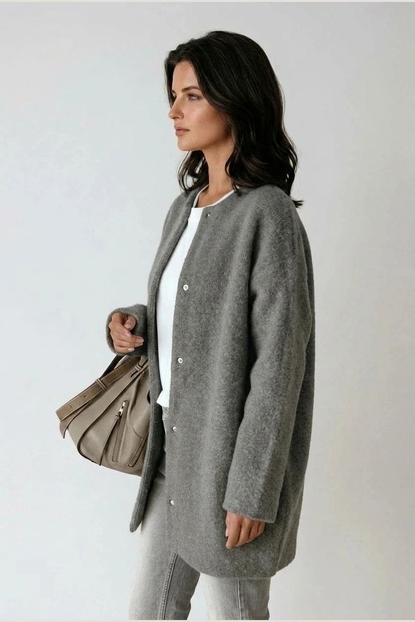 Kvinde i lang oversize cardigan med rund hals og knapper, hvid t-shirt, jeans og sneakers._8