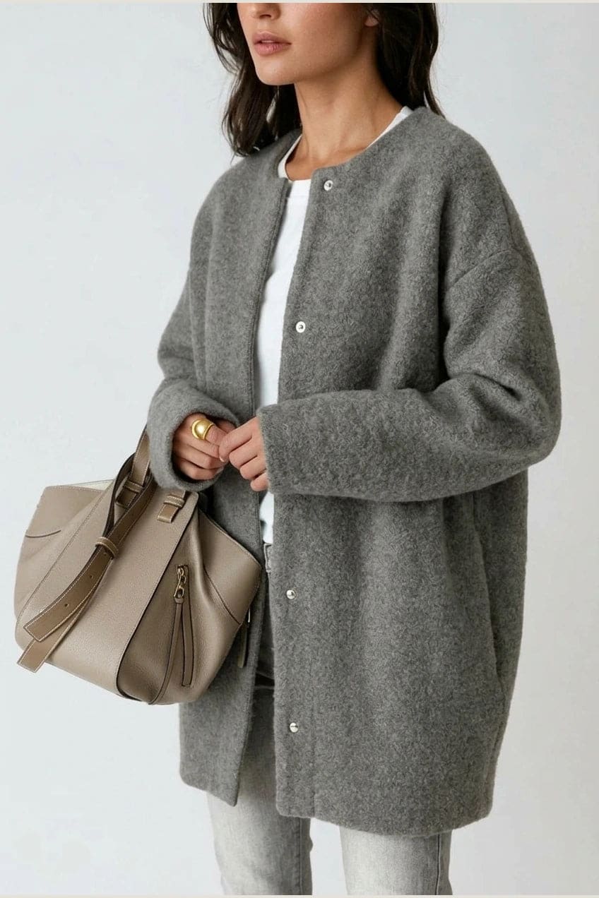 Kvinde i lang oversize cardigan med rund hals og knapper, hvid t-shirt, jeans og sneakers._9