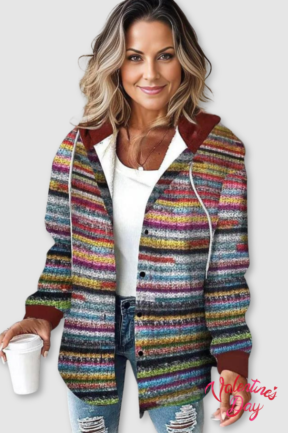 Kvinde iført farverig strikket cardigan med striber, hætte og lommer over hvid top og jeans_0