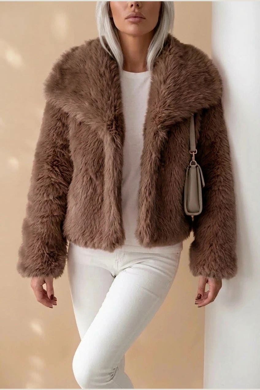 Kort jakke i fake fur med stor krave, åben front og voluminøse ærmer, båret over en enkel top og smalle bukser._4