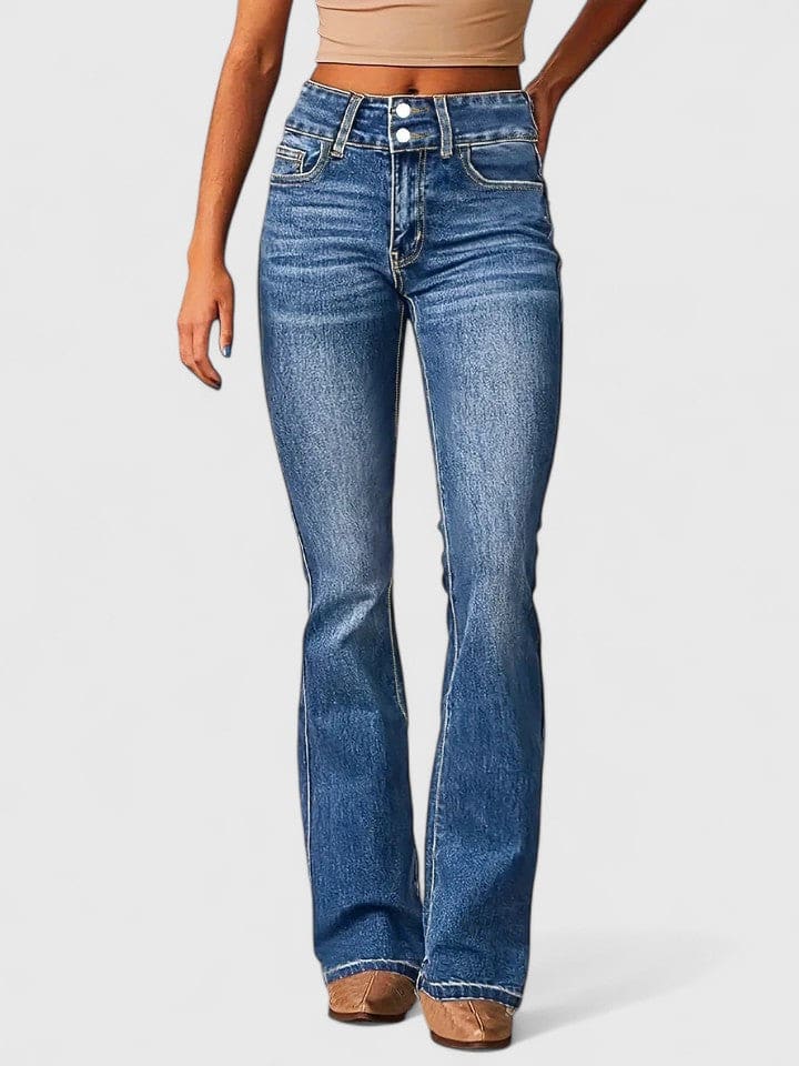 Kvinde iført flared jeans med høj talje og dobbelt knaplukning i mellemblå vask, stylet med nude crop top og brune støvletter._0
